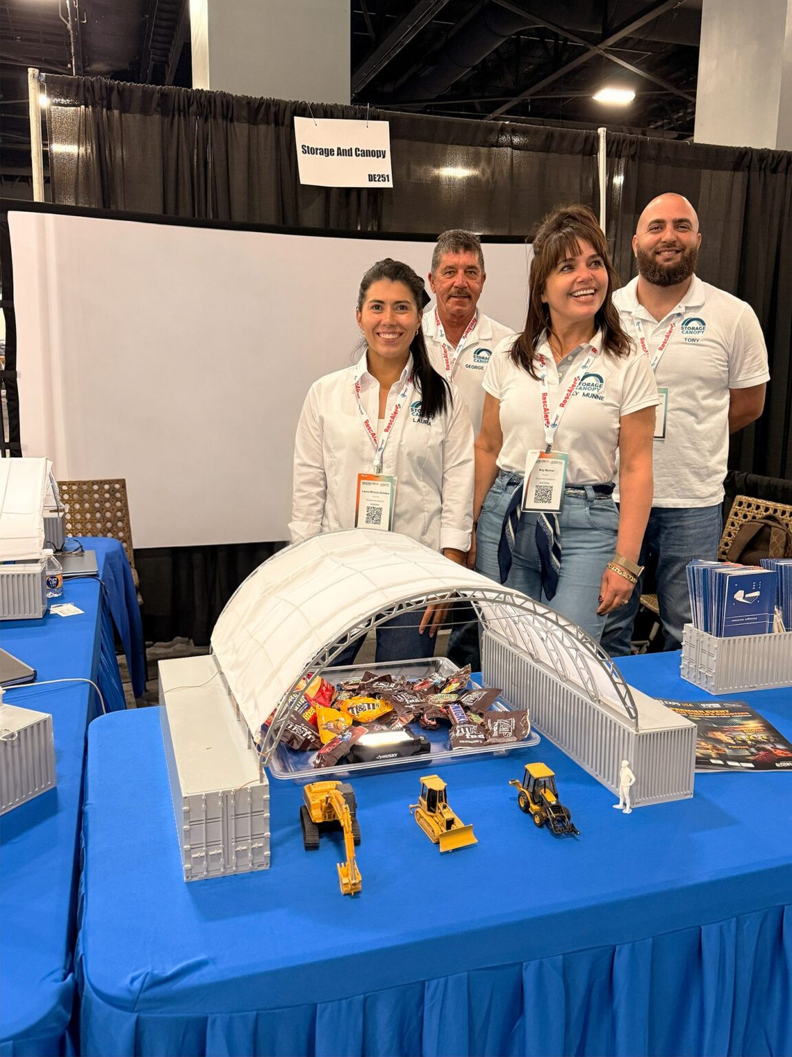 Storage & Canopy team at their Disaster Expo USA booth with a shipping container canopy model